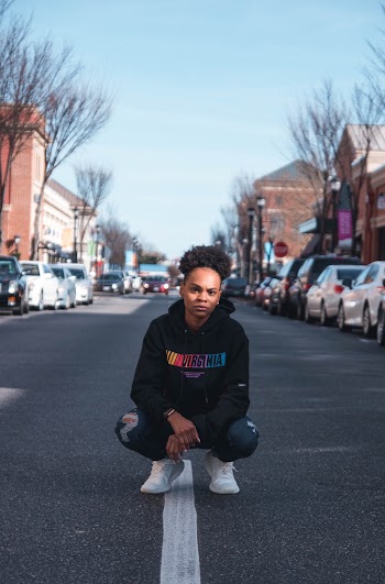 Person Wearing Hoodie Sitting in the Middle of the Street