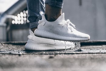 person wearing pair of cream white Adidas Yeezy Boost 350 shoes