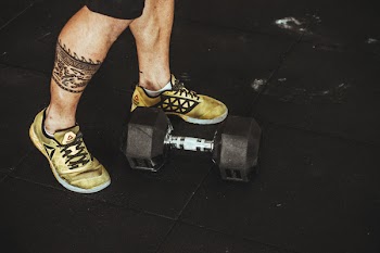 Person Wearing Pair of Gold-and-black Sneakers