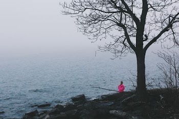 person wearing pink dress sitting near ocean