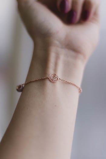 Person Wearing Pink Gold-colored Faith Bracelet