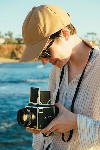 Person  Wearing Pinstriped Sport Shirt Holding Camera