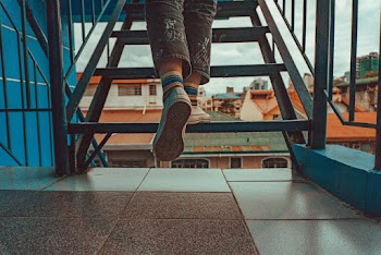 Person Wearing Rainbow Socks While Walking Upstairs