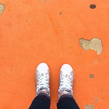 Person Wearing Sneakers Standing on Orange Floor