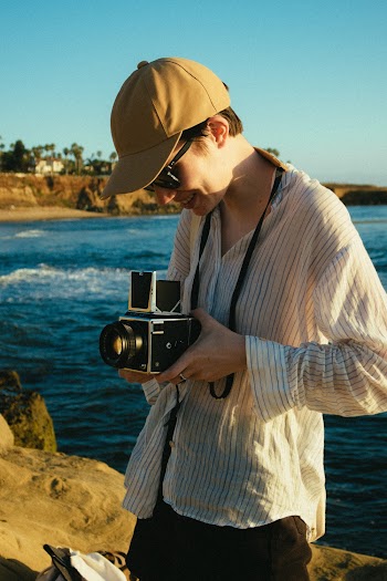Person Wearing Striped Dress Shirt Holding Camera