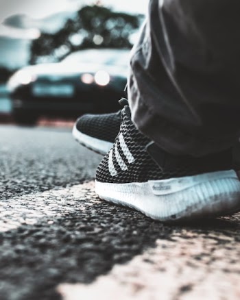 Person Wearing White-and-black Adidas Running Shoes
