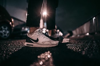 person wearing white and black Nike shoes