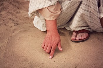 Person Wearing White and Gray Striped Dress Touching Brown Sand