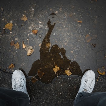 Person Wearing White Low-top Shoes Taking Photo of Water