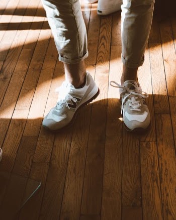 person wearing white New Balance shoes