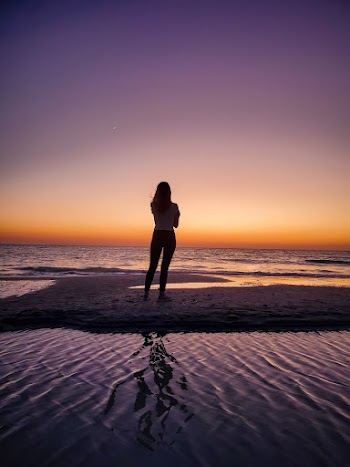 Person Wearing White Shirt Standing and Facing on Body of Water