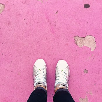 Person Wearing White Sneakers Standing on Pink Floor