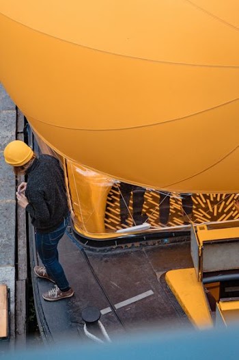 person wearing yellow hard hat near road
