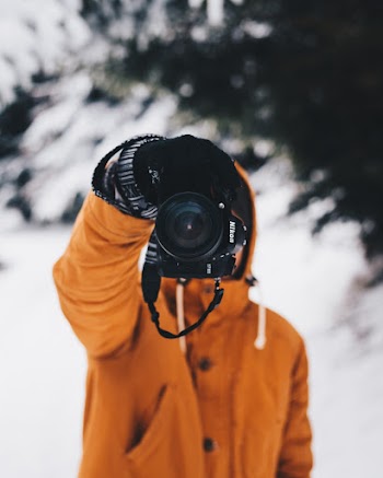 Person Wearing Yellow Jacket Holding Nikon Dslr Camera