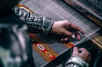 person weaving gray cloth