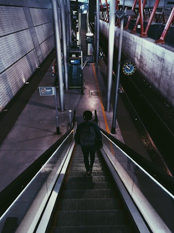 Person With Backpack Riding Escalator