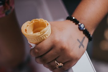 Person With Beaded Bracelet And Ring Holding Ice Cream Cone