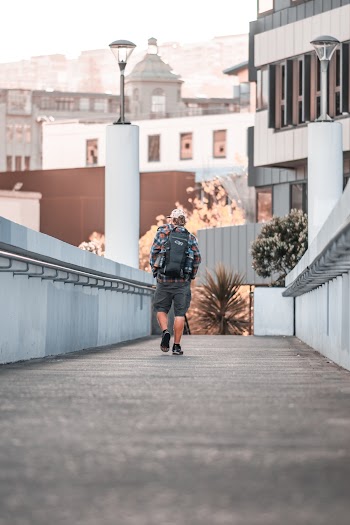 Person With Black Backpack Walking on Pathway