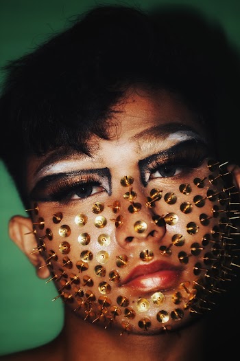 Person With Eye Makeup and Thumb Tacks on Face