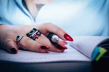 Person With Red Nail Polish Holding Black Pen