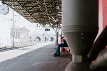 Person working on a laptop at a train station