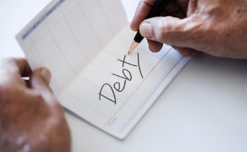 Person Writing Debt on Paper