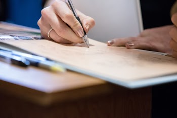 Person Writing On Brown Paper