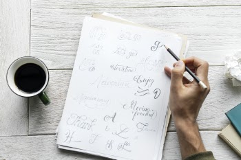 Person Writing on Paper Sheet