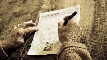 Person Writing on Puzzle &amp; Win Paper