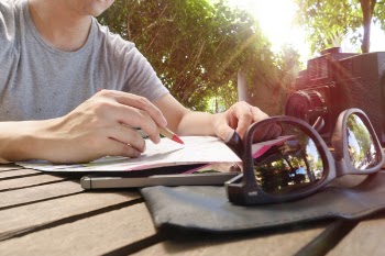 Person Writing on Sketchbook
