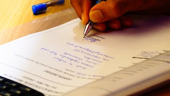 Person Writing on White Paper