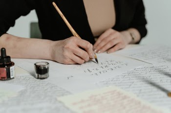Person Writing on White Paper