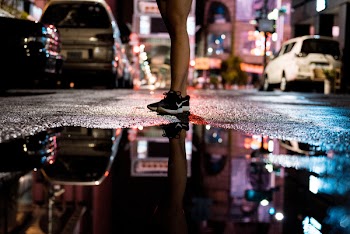 Persons Standing on Asphalt Road Near of Body of Water