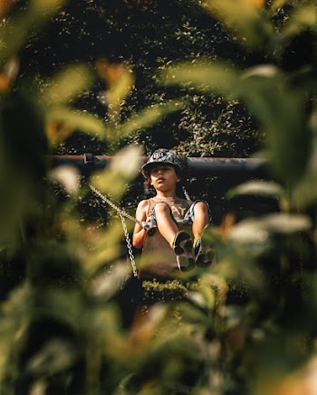 Photo of a Boy Sitting on Swing