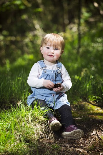 Photo of a Girl Sitting on Green Grass Field