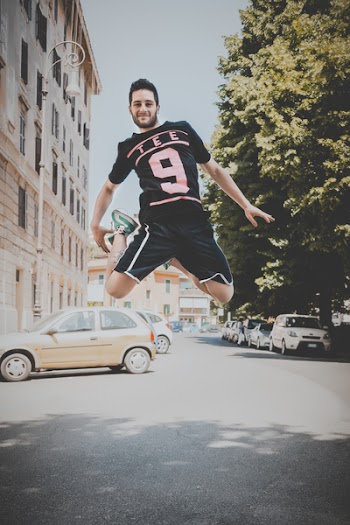 Photo of a Guy Jumping on Road