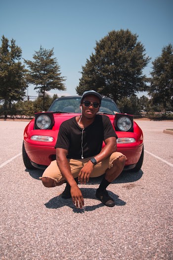 Photo of a Man in Front of Red Car