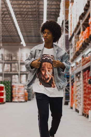 Photo of a Man in Gray Jacket and White Printed T-Shirt  Walking Inside Supermarket