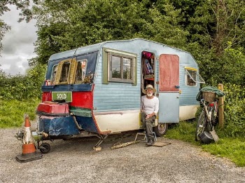 Photo Of A Man In White Long-sleeved Top on Blue And White Pop-up Camper