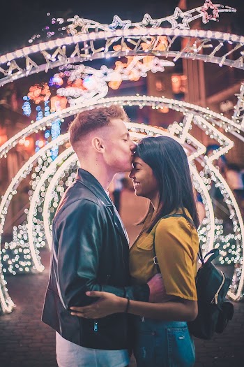 Photo of a Man Kissing a Woman on Forehead While Holding Each Other