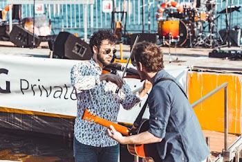 Photo of a Man Playing Violin Beside a Man Playing Guitar