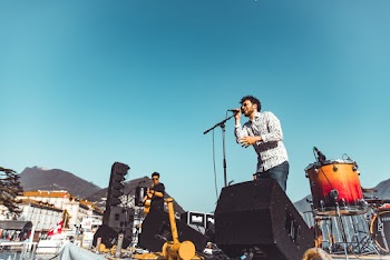 Photo of a Man Singing on Stage