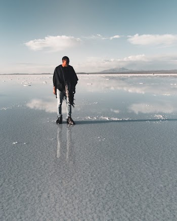 Photo of a Man Standing on Low Tide Seabed