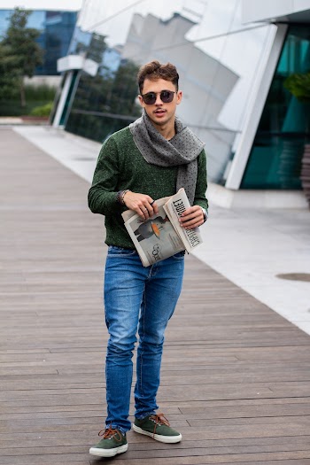 Photo of a Man Standing While Holding a Newspaper