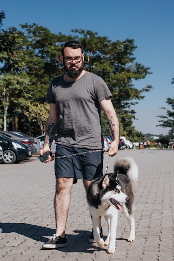 Photo of a Man Walking with a Siberian Husky