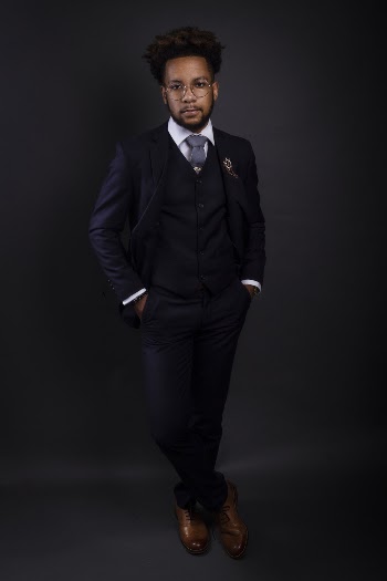 Photo of a man wearing a black three piece suit