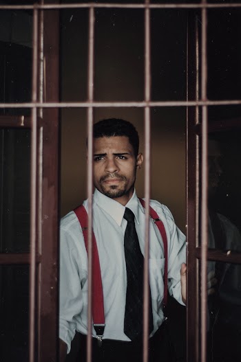 Photo of a man wearing dress shirt and necktie behind window