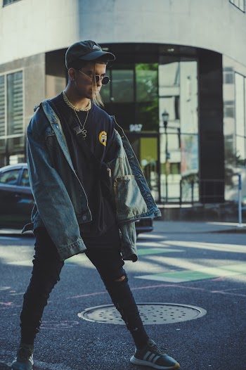 Photo of a man wearing hat and denim jacket at the street