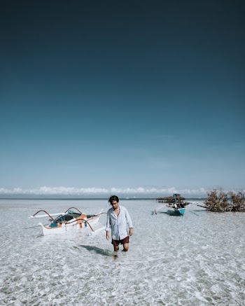 Photo of a Man Wearing White Top on the Beach 