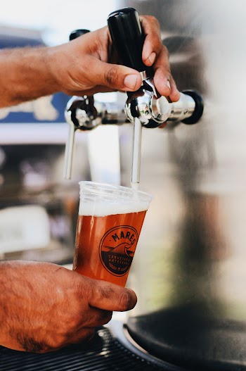 Photo of a Person Pouring Beer in a Clear Mares Beer Glass From a Beer Dispenser Machine